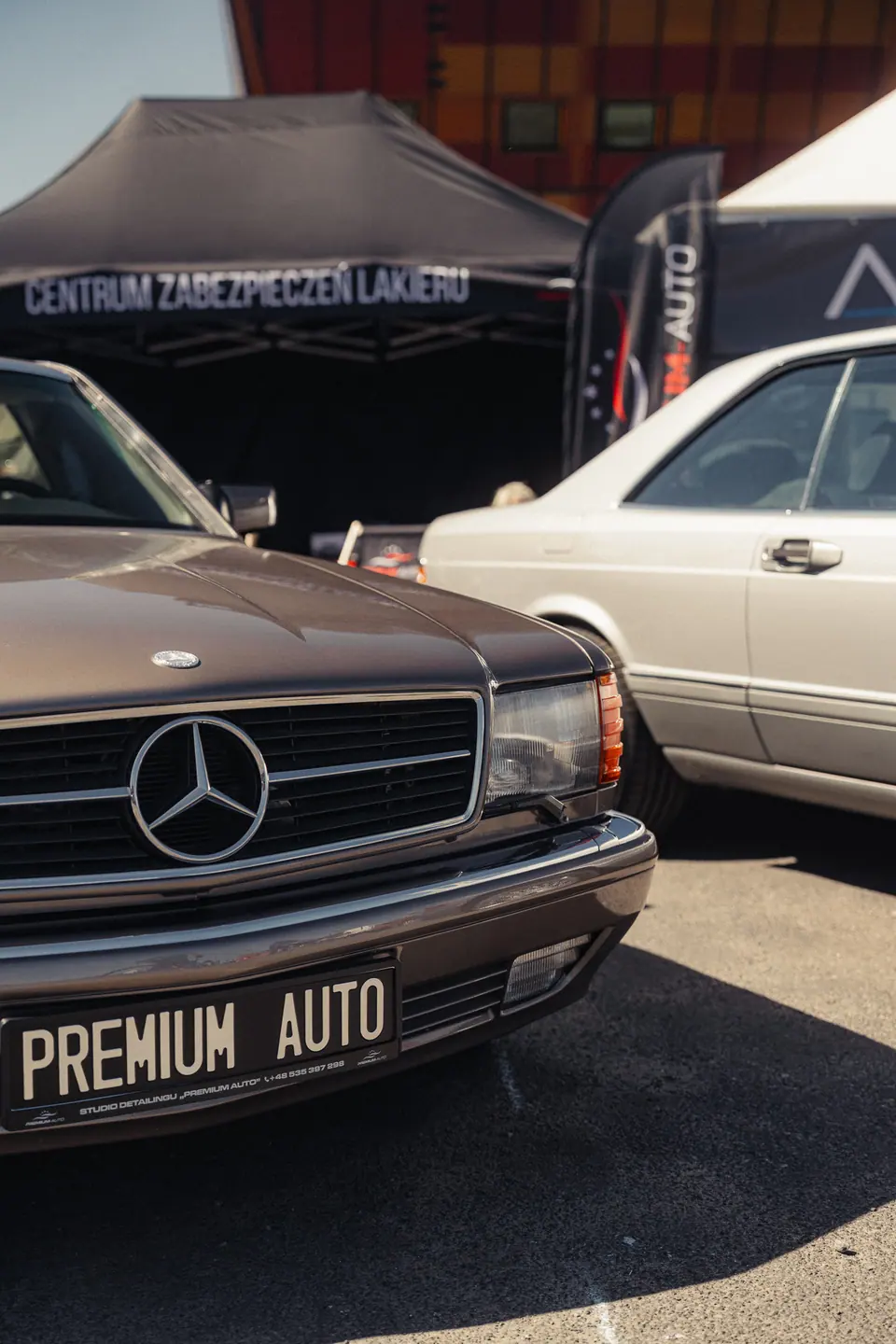 W126 SEC przed stoiskiem Premium-Auto – zlot Klasyczny Szczecin 2025, stoisko Centrum Zabezpieczeń Lakieru, Łasztownia, Szczecin