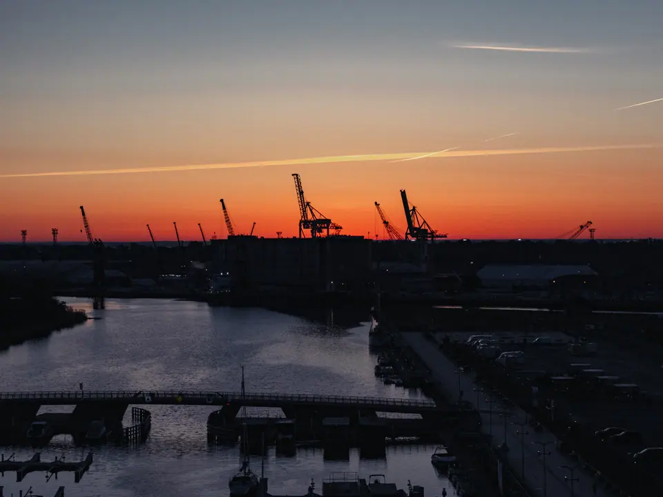 Dźwigi portowe o wschodzie słońca – Szczecin z drona, wschód słońca nad Odrą i Wałami Chrobrego, Łasztownia, Szczecin